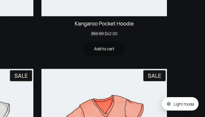 A WooCommerce shop page in dark colours: near-black background, off-white site name, menu, headings and prices, and product pictures of hoodies and T-shirts unchanged. A white pill button in the bottom-right corner reads Light mode.